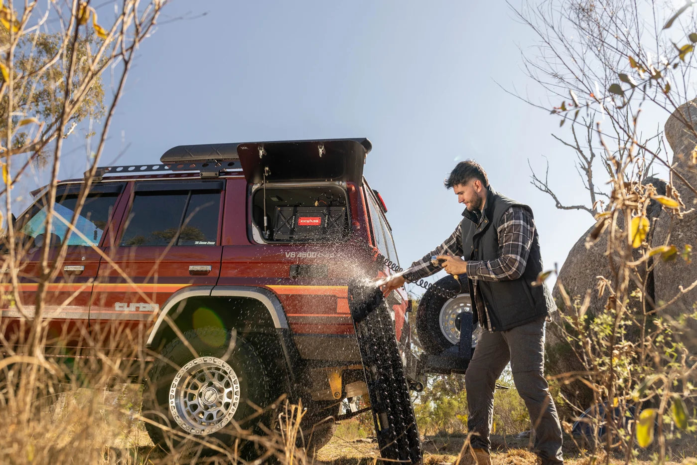 Rinsing gear beside a four-wheel drive with an installed AquaBoss tank