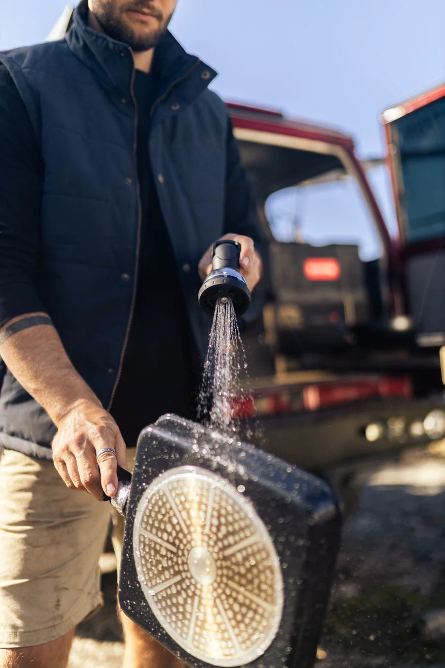 Washing a camp cooking pan with an AquaBoss spray head